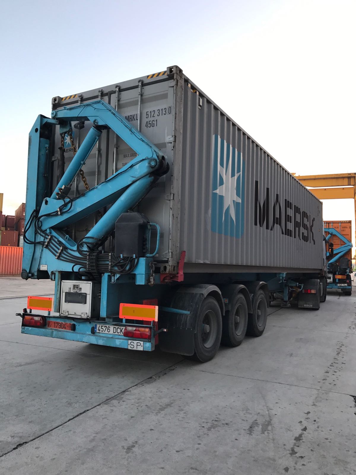 Carga de contenedor en camión con grúa hidráulica articulada